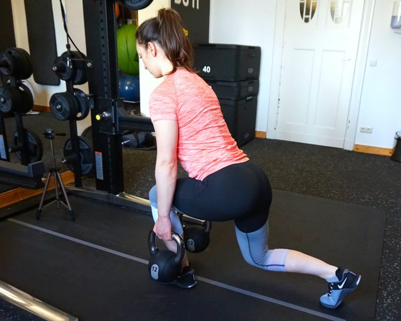 A girl performing a forward-lean reverse lunge.
