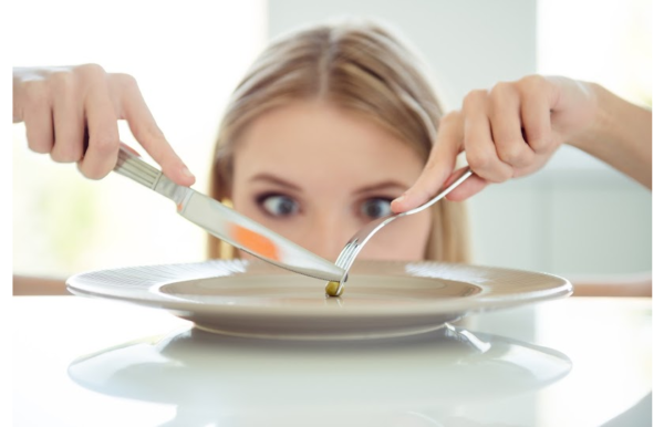 The girl staring at an almost empty plate fooled by popular weight loss myths from the article "10 Worst weight loss myths delaying your success"